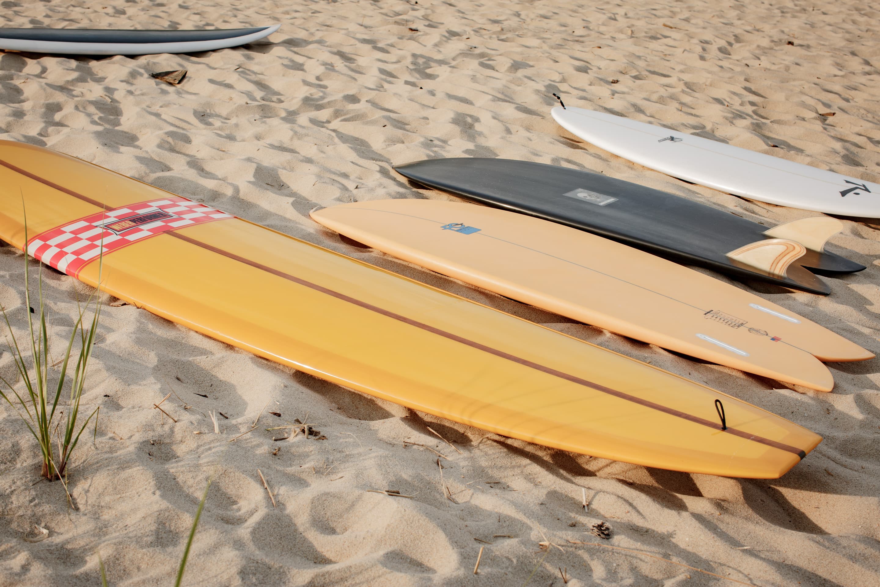 A quiver of community-listed surfboards on the sand