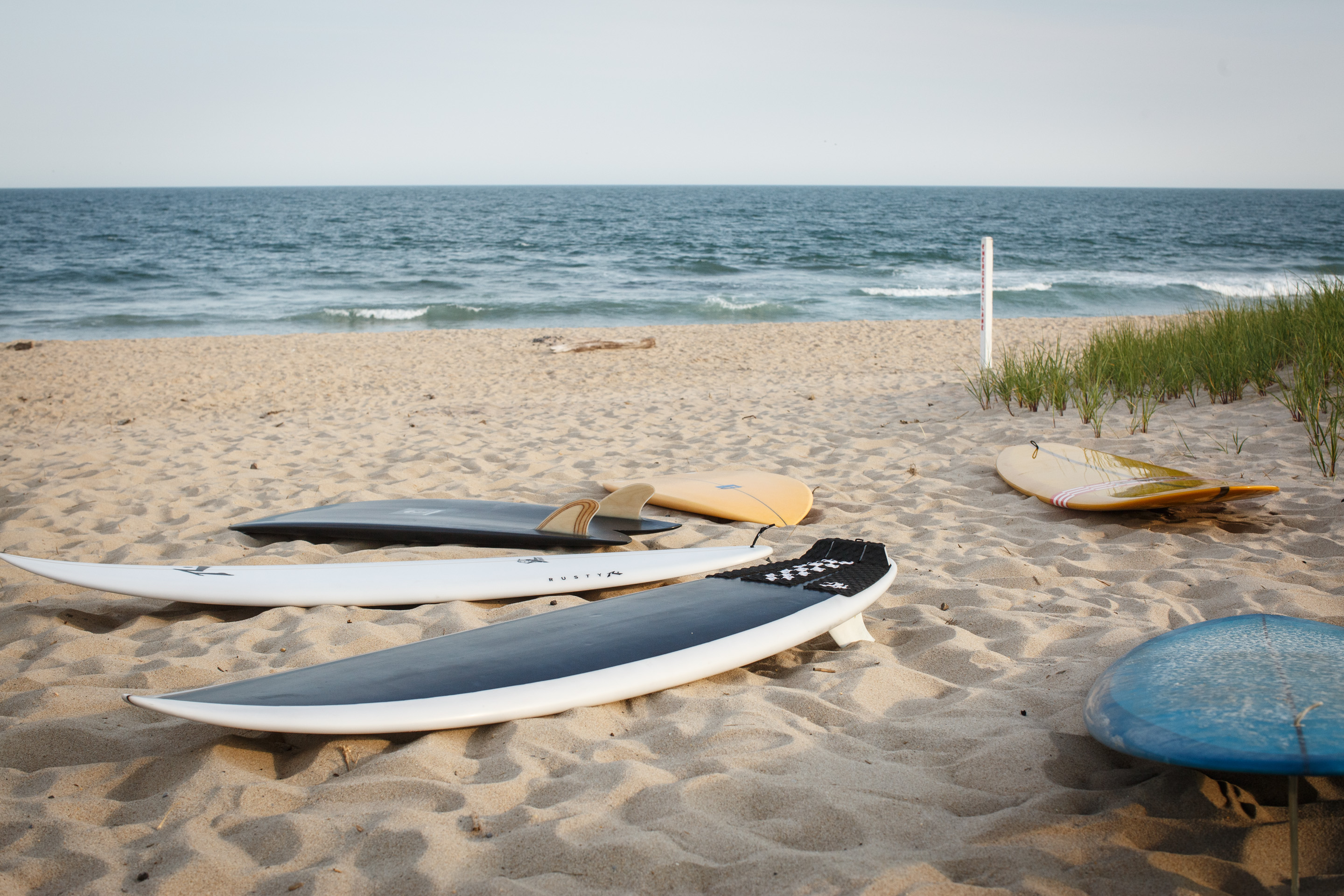Surfboard quiver lined up at the beach ready for rental at Strictly Surf Amagansett