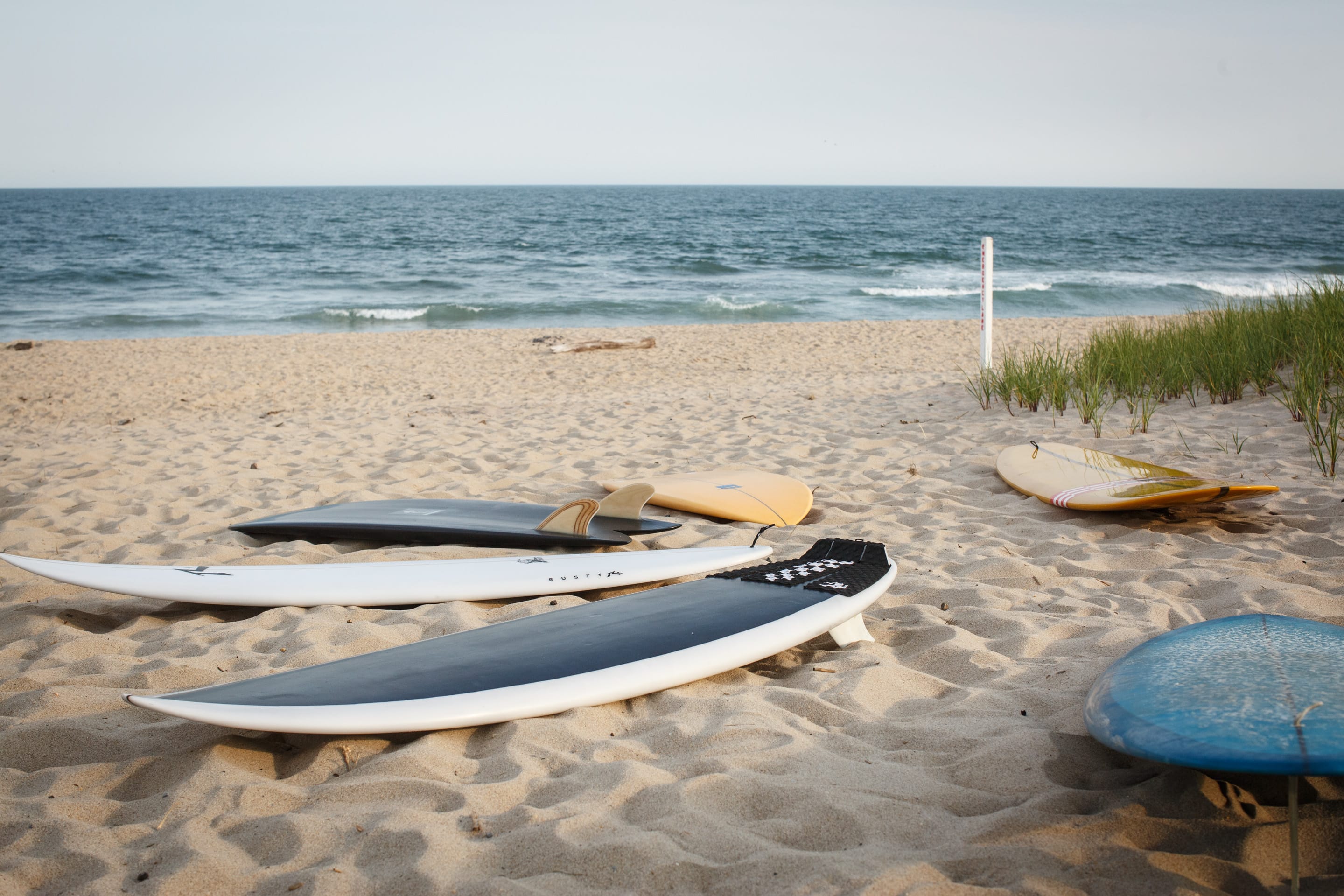 Surfboard quiver lined up at the beach ready for rental at Strictly Surf Amagansett